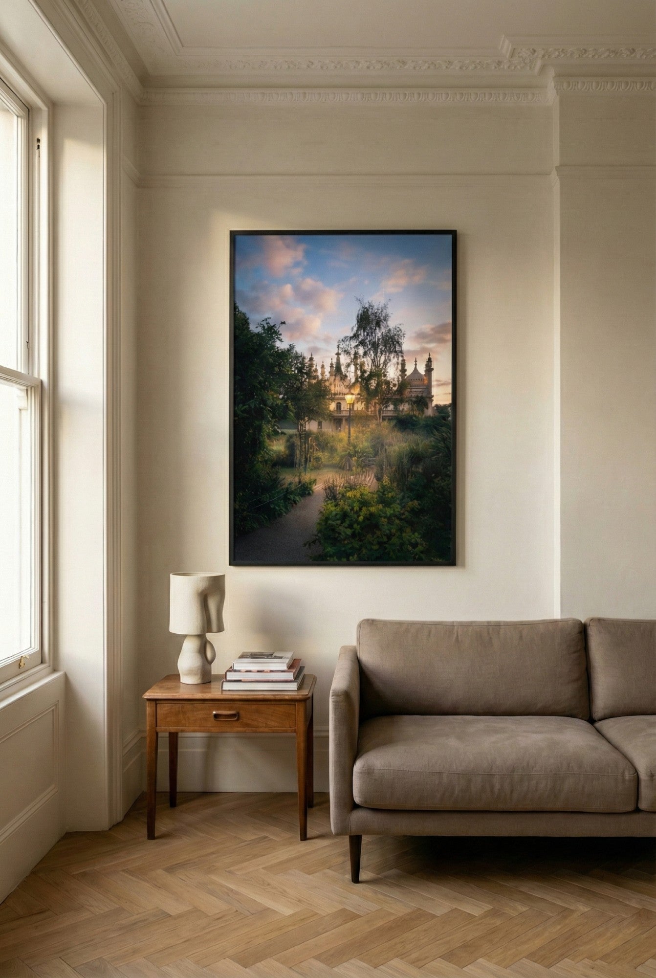 Living room with a large framed painting on the wall, a sofa, and a side table.